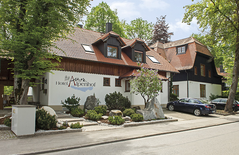 Hotel Alpenhof Gauting im Frühling – Außenansicht mit blühendem Garten